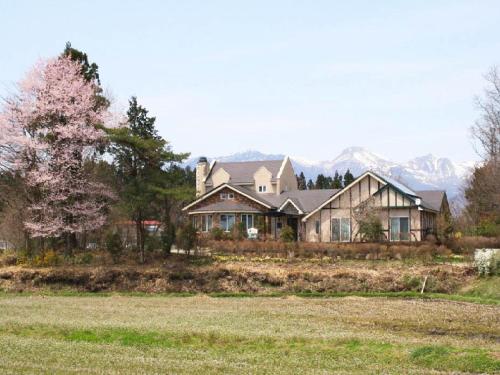 une grande maison avec des montagnes en arrière-plan dans l'établissement Gasthof yell / Vacation STAY 79350, à Kuroiso
