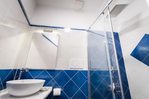 ein blau-weißes Bad mit einem WC und einer Dusche in der Unterkunft Moon'n Sea in Minori