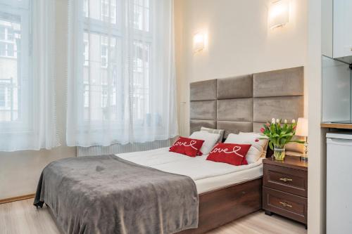a bedroom with a large bed with red pillows at Apartamenty Przytulne Starówka Old Town Ogarna in Gdańsk
