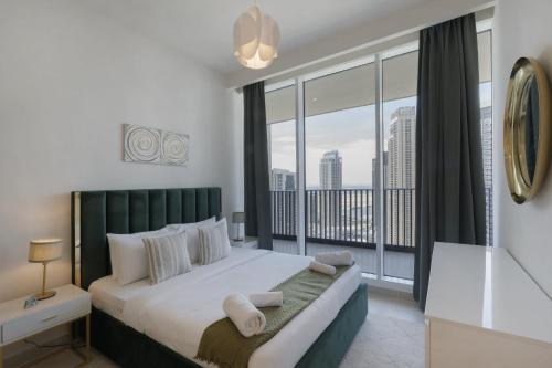 a bedroom with a large bed with a large window at Harbour Gate 1 - 2BR Apartment - Allsopp&Allsopp in Dubai