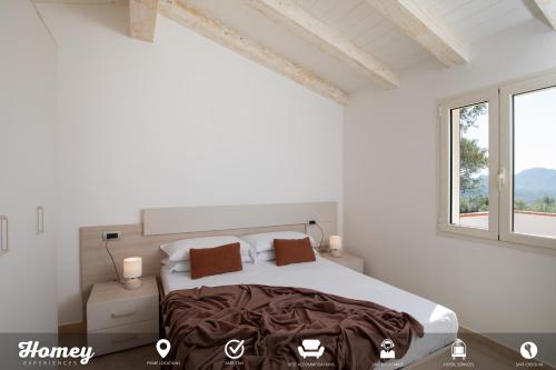 Un dormitorio blanco con una cama grande y una ventana en Borgo dei Fiori - Homey Experience, en Cugnana