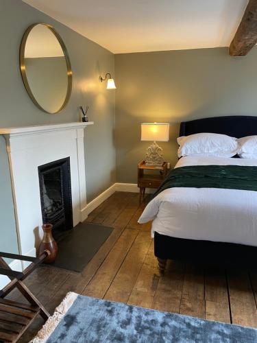 a bedroom with a bed and a mirror and a fireplace at Hurdley House-Georgian Town House in Montgomery