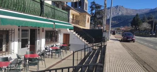 a building with tables and chairs on a street at Posada Ojedo Los Ñeros in Ojedo