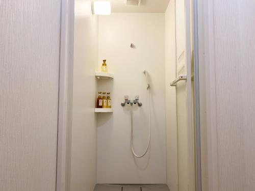 a bathroom with a shower with a shower head at Guesthouse KOBE YAMATOMUSUBI in Kobe