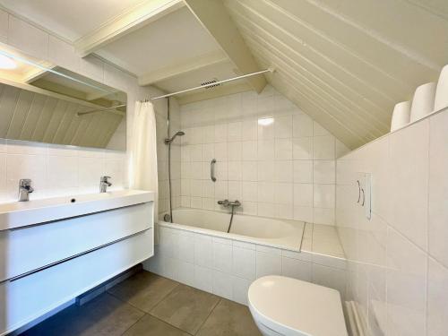 een badkamer met een bad, een toilet en een wastafel bij Vakantiehuis 't Boerderietje in Koudekerke