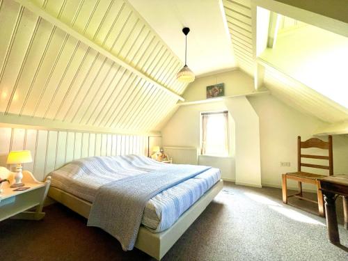 een slaapkamer met een groot bed op zolder bij Vakantiehuis 't Boerderietje in Koudekerke