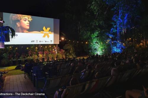 a crowd of people sitting in chairs in front of a screen at ZenLux: 4BR Bayview Mansion Infinity Pool + Cinema in Stuart Park