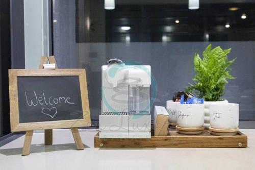 a table with a blender and a chalk board at ZenLux: 4BR Bayview Mansion Infinity Pool + Cinema in Stuart Park