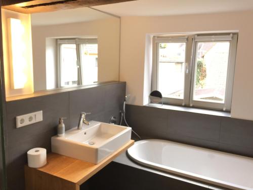 een badkamer met een wastafel en een bad bij Apartment Rampendal im Lemgoer Fachwerkhäuschen in Lemgo