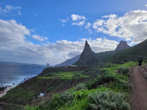 a man walking down a dirt road next to the ocean at Cosy twin beds El Galeon in Santa Cruz de Tenerife