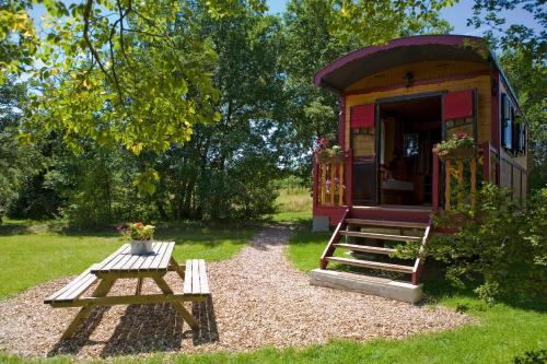 a tiny house with a picnic table and a bench at Domaine de la Grangée in La Chapelle-Blanche-Saint-Martin