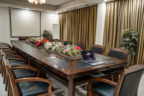 - une salle de conférence avec une longue table et un ordinateur portable dans l'établissement 万象建国大酒店, 