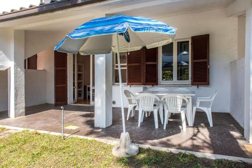 einen Tisch und Stühle unter einem Sonnenschirm auf einer Terrasse in der Unterkunft M049 - Marcelli, trilocale con giardino a 200 metri dal mare in Marcelli