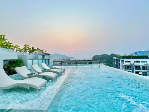 a swimming pool with lounge chairs on a building at ECOndo Bangsaray in Bang Sare