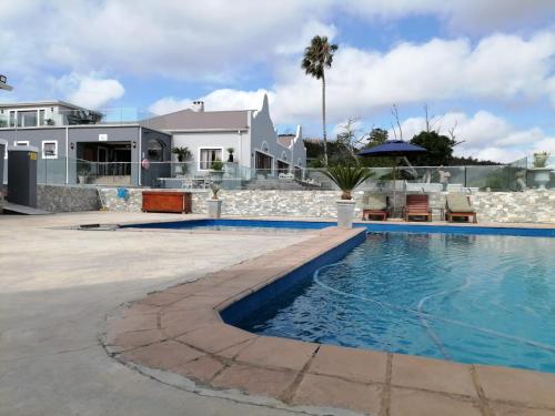 a swimming pool in front of a house at Issaquena Heights Boutique Hotel in Knysna