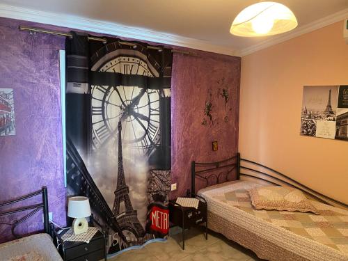- une chambre avec un lit et une horloge murale dans l'établissement Three islands, à Mégare