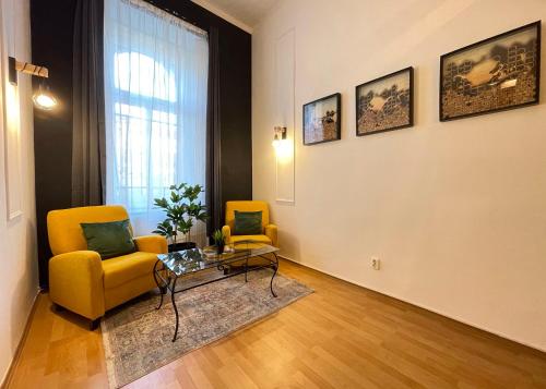 a living room with two yellow chairs and a table at Smart Hotel Budapest in Budapest