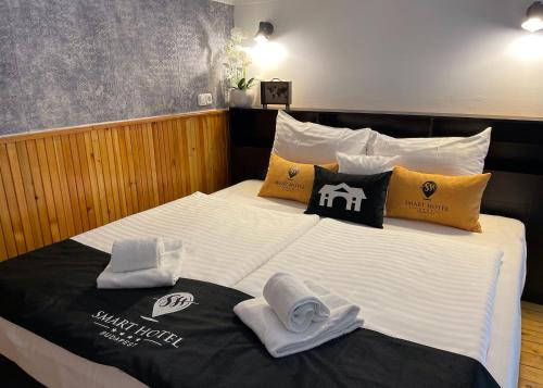 a bedroom with a bed with towels on it at Smart Hotel Budapest in Budapest