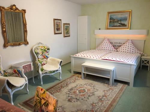 sypialnia z łóżkiem, krzesłami i dywanem w obiekcie Chalet MOOS w mieście Todtmoos