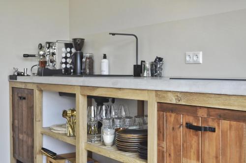 a kitchen with a counter with dishes on it at Van Heeckeren Apartments & Suites Buren in Buren