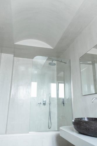 a white bathroom with a shower and a sink at Casa Vitae Suites in Kamari