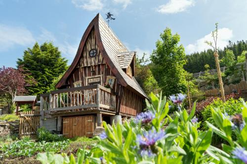 ein Holzhaus mit einem Gameradach in der Unterkunft Haberjockelshof in Titisee-Neustadt