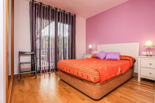 カンブリルスにあるEsquirol Litoral - ONLY FAMILIESのベッドルーム(紫色の枕とベッド付)