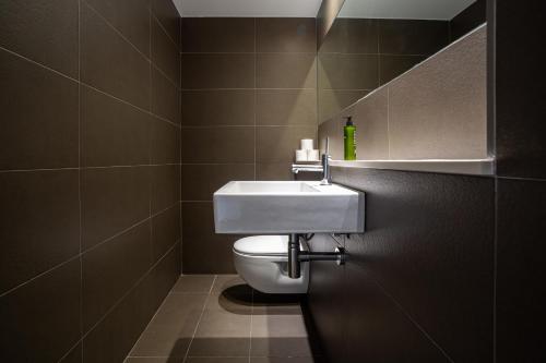 a bathroom with a white toilet and a sink at Migjorn Ibiza Suites & Spa in Playa d'en Bossa