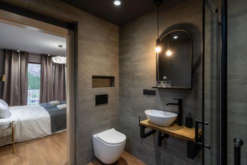a bathroom with a toilet and a sink and a bed at ZaKa Apartments in Krakow