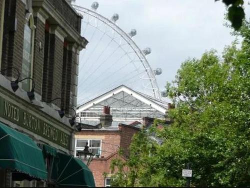a ferris wheel in the background of a city with buildings at APlaceToStay Central London Apartment, Waterloo (STA) in London