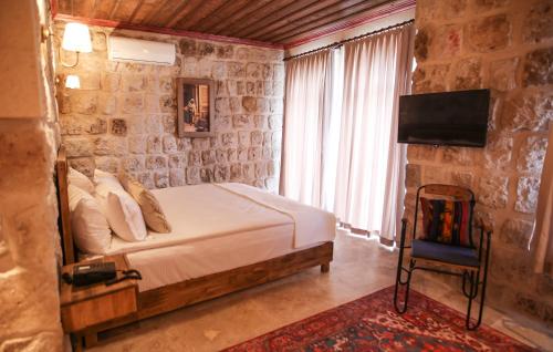 a bedroom with a bed and a tv in a room at Cappadocia Vita Cave Hotel in Urgup