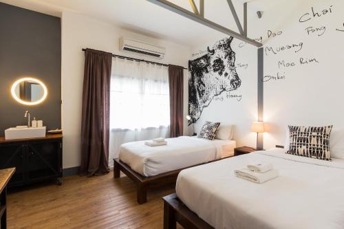 a bedroom with two beds and a window at Ombra House No. 21-24 in Chiang Mai