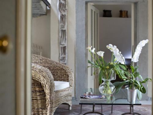 a wicker chair and a vase with flowers on a table at B&B Casa del Nonno in Adrara San Rocco
