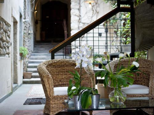 dwa wiklinowe krzesła i stół z kwiatami w obiekcie Bed and Breakfast Casa del Nonno w mieście Adrara San Rocco