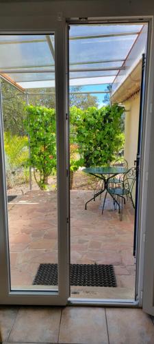 an open door to a patio with a table at Le Mas du Rouquan in Vidauban