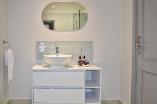 a bathroom with a sink and a mirror at Serenity Ocean Lodge in Wilderness