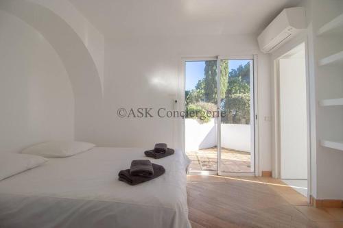 une chambre avec un lit blanc avec deux serviettes dessus dans l'établissement Villa L'Oranger vue mer et piscine, à La Croix-Valmer