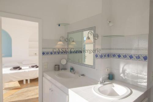 une salle de bain blanche avec un lavabo et un miroir dans l'établissement Villa L'Oranger vue mer et piscine, à La Croix-Valmer