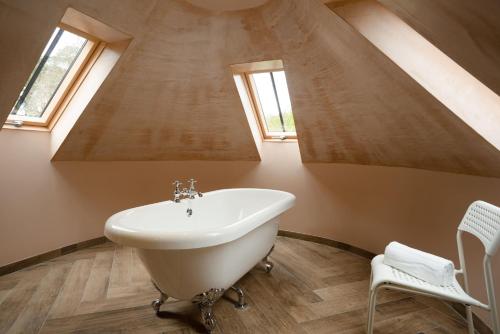 een badkamer met een wit bad en een raam bij Kincraig House - Seasgair Lodges in Kincraig