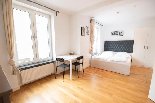a bedroom with a bed and a desk in it at Charming Apartments Frankfurt City in Frankfurt