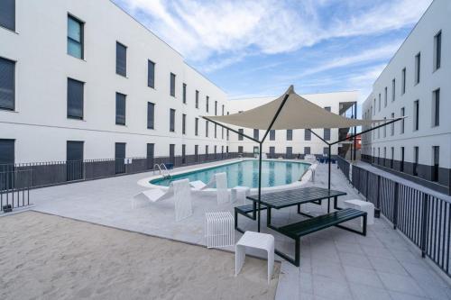 a patio with a table and chairs and a pool at Micampus Alicante in San Vicente del Raspeig