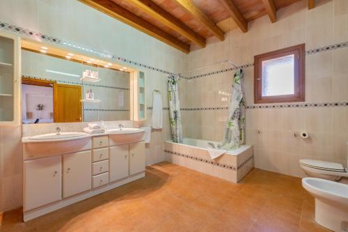 a bathroom with two sinks and a shower and a toilet at Finca Can Muvi in Santanyi