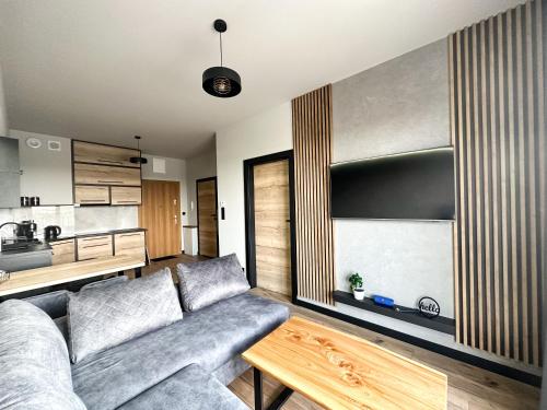 una sala de estar con un sofá y una mesa en ApartLoft 64 Apartament Zator, en Zator
