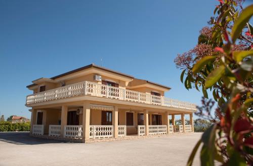 a large yellow house with a large balcony at B&B La Terrazza Degli Scrittori in Racalmuto