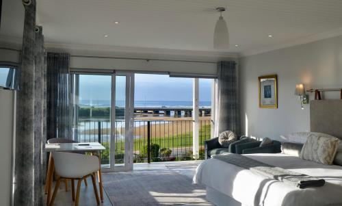 a hotel room with a bed and a balcony at Serenity Ocean Lodge in Wilderness