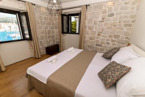 a bedroom with two beds and a stone wall at Apartman Ciciliani in Trogir