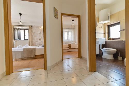 a bathroom with a toilet and a bed in a room at Apartman Ciciliani in Trogir