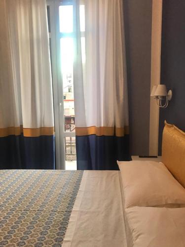 a bedroom with a bed and a window with curtains at B&B I Due Teatri in Naples