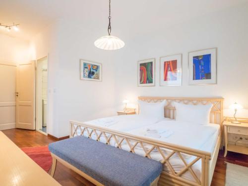 Schlafzimmer mit einem großen weißen Bett und einer blauen Bank in der Unterkunft Appartementhaus Sonnenbad - Luxuspenthouse App. 11 in Sassnitz