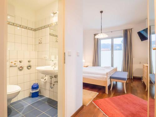 ein Bad mit einem Waschbecken und ein Bett in einem Zimmer in der Unterkunft Appartementhaus Sonnenbad - Luxuspenthouse App. 11 in Sassnitz